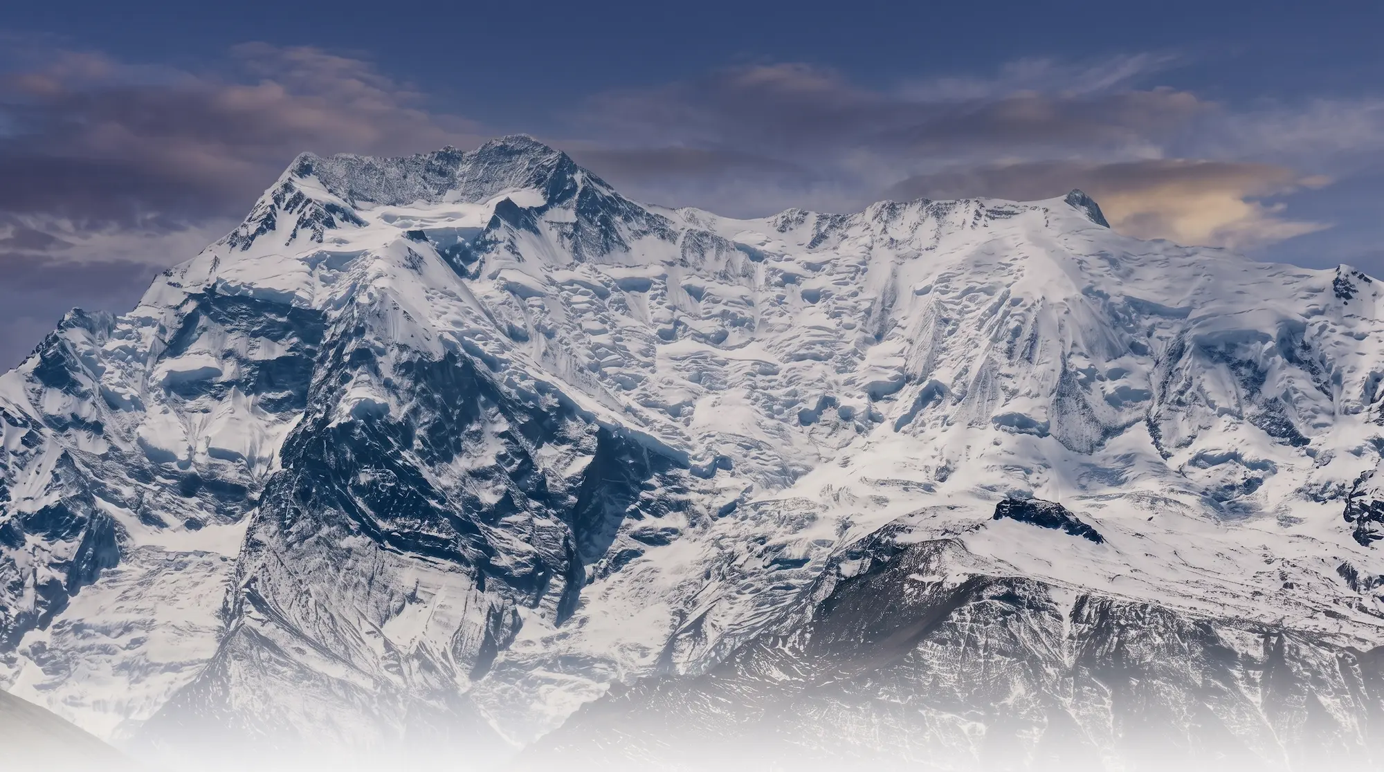 Wide landscape view of the Annapurna IV mountain face and glaciated climbing route at 7525m in the Himalayas of Nepal.
